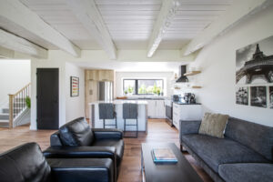 Maison Maitland heritage renovation after photo, showing kitchen and dining room and the exposed beams they kept. 