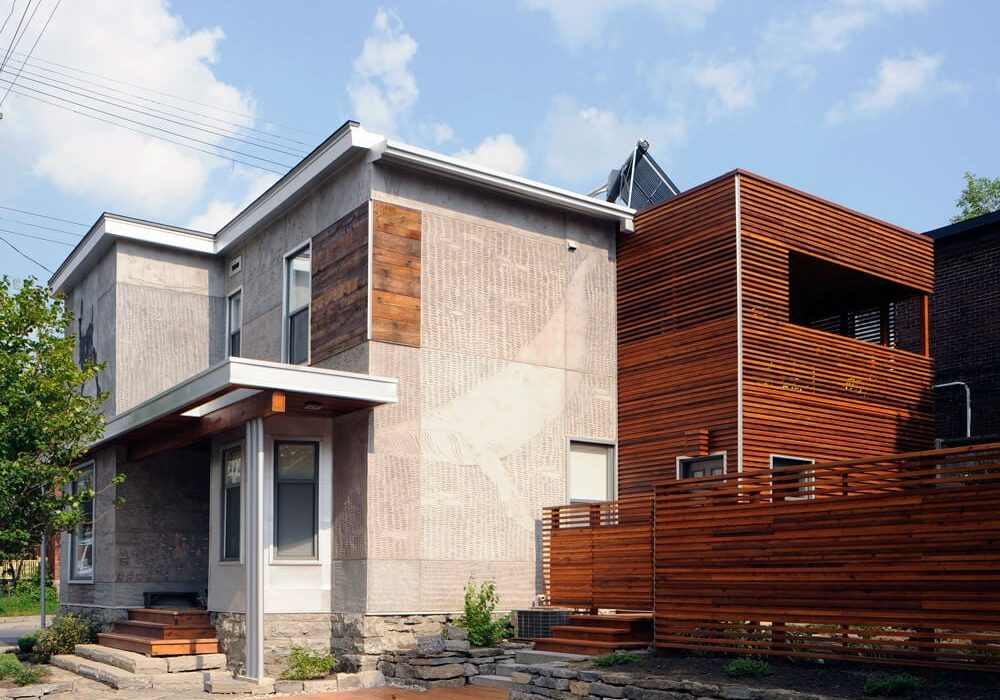 Amsted custom home nestled in the Ottawa landscape, featuring a modern stone facade and sleek lines that blend effortlessly with the scenic surroundings.